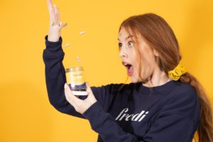 woman in black long sleeve shirt holding clear drinking glass